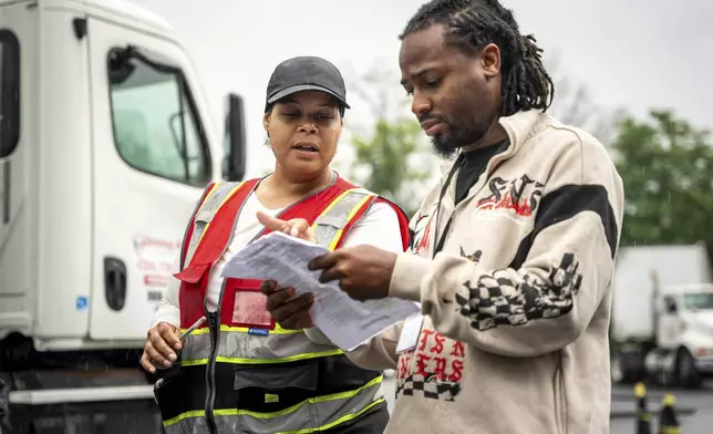 An instructor helps a student study at the Driving Academy on Tuesday, June 10, 2025 in Linden, N.J. where students prepare to obtain a Commercial Driver’s License (CDL) with multilingual instructors. (AP Photo/Angelina Katsanis)