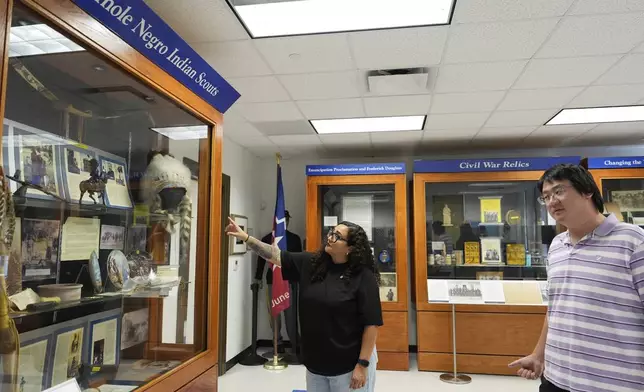 Director of Education Dr. Michelle Tovar, center, and archivist Jason Fung describe how current displays will be redone inside the Buffalo Soldiers National Museum on Friday, June 27, 2025, in Houston, Texas. (AP Photo/Ashley Landis)