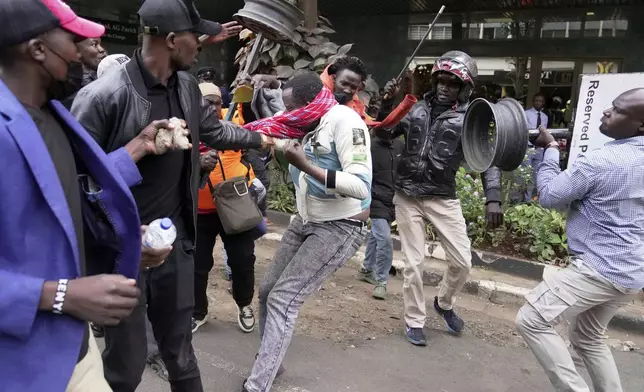 CORRECTS ACTION TO ATTACKED - A suspected pro government supporter is attacked by protesters during a demonstration over the death of blogger Albert Ojwang in police custody, in downtown Nairobi, Kenya, Tuesday, June 17, 2025. (AP Photo/Brian Inganga)