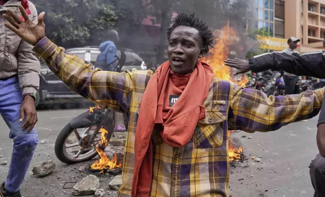 A protester gestures as police fire teargas at them during a demonstration over the death of blogger Albert Ojwang in police custody, in downtown Nairobi, Kenya, Tuesday, June 17, 2025. (AP Photo/Brian Inganga)