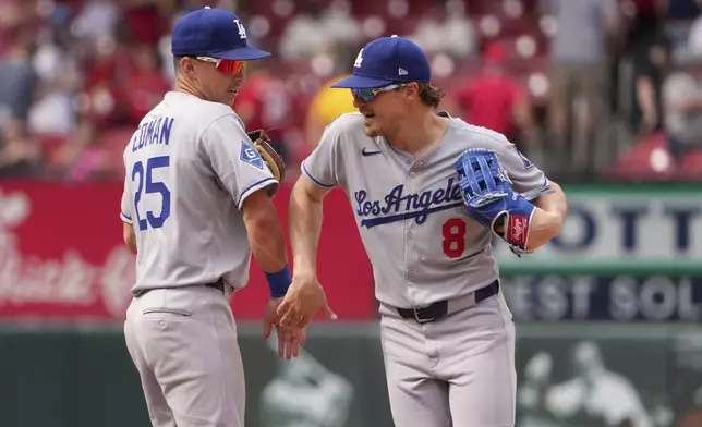 Los Angeles Dodgers' Tommy Edman and teammate Enrique Hernandez (8) celebrate a victory over the St. Louis Cardinals following baseball game Sunday, June 8, 2025, in St. Louis. (AP Photo/Jeff Roberson)
