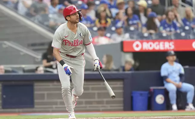 Philadelphia Phillies' Trea Turner (7) watches the flight of the ball after hitting a two-run home run off Toronto Blue Jays pitcher Bowden Francis during the first inning of a baseball game in Toronto, Tuesday June 3, 2025. (Chris Young/The Canadian Press via AP)