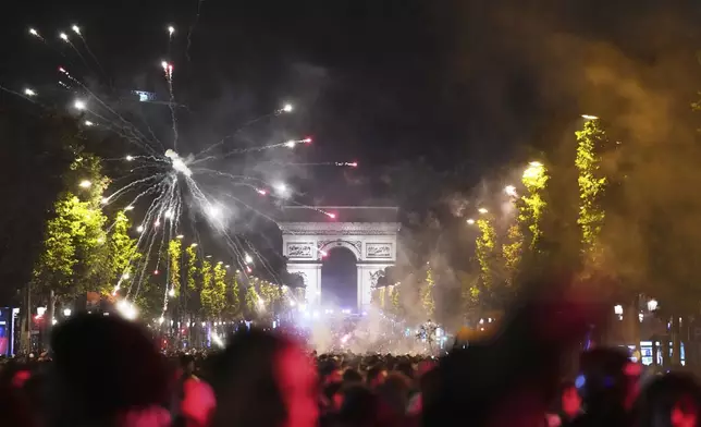 Soccer fans celebrate PSG's victory on the Champs-Elysees avenue after the Champions League final soccer match between Paris Saint-Germain and Inter Milan, Sunday, June 1, 2025 in Paris. (AP Photo/Aurelien Morissard)