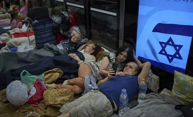 People take shelter in an underground metro station as a precaution against possible Iran missile attacks, in Ramat Gan, near Tel Aviv, Israel, Tuesday, June 17, 2025. (AP Photo/Oded Balilty)