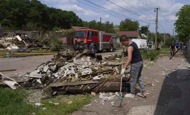 People clear the rubble of residential houses destroyed by a Russian drone strike in Pryluky village, Ukraine, Thursday, June 5, 2025. (AP Photo/Evgeniy Maloletka)