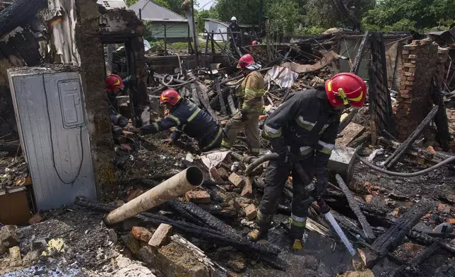 Rescue workers extinguish a fire of a house destroyed by a Russian drone strike in Pryluky village, Ukraine, Thursday, June 5, 2025. (AP Photo/Evgeniy Maloletka)