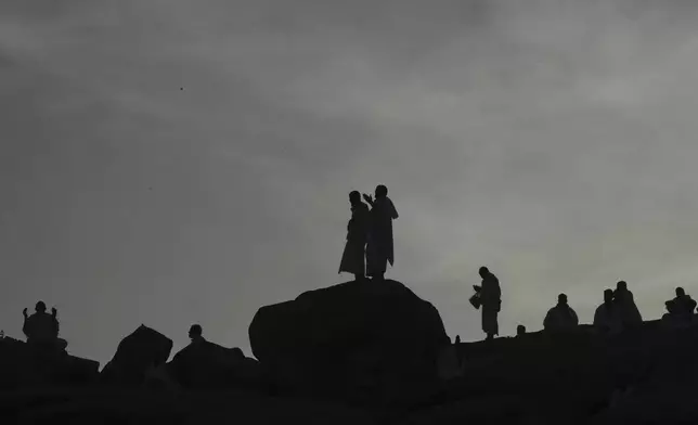 Muslim pilgrims offer prayers at top of the rocky hill known as the Mountain of Mercy, on the Plain of Arafat, during the annual Hajj pilgrimage near the holy city of Mecca, Saudi Arabia, Thursday, June 5, 2025. (AP Photo/Amr Nabil)