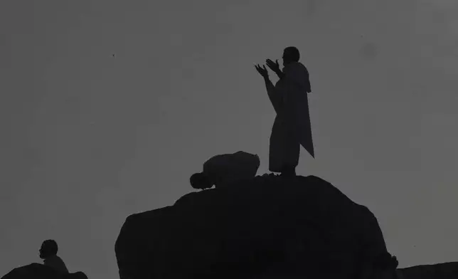 Muslim pilgrims offer prayers at top of the rocky hill known as the Mountain of Mercy, on the Plain of Arafat, during the annual Hajj pilgrimage near the holy city of Mecca, Saudi Arabia, Thursday, June 5, 2025. (AP Photo/Amr Nabil)