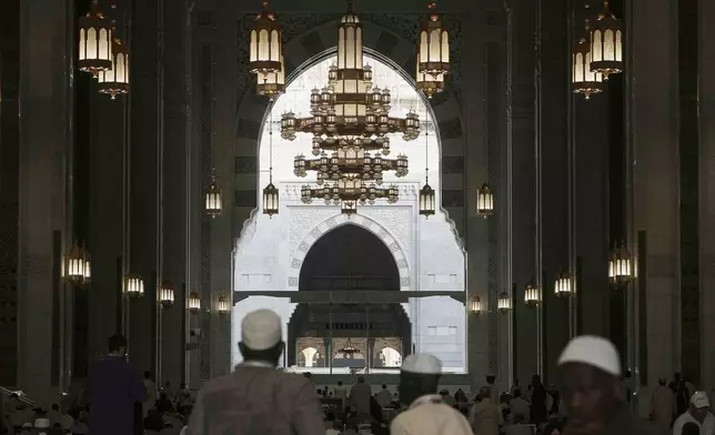 Muslim pilgrims stand in front the Kaaba, the cubic building at the Grand Mosque, during the annual Hajj pilgrimage, in Mecca, Saudi Arabia, Tuesday, June 3, 2025. (AP Photo/Amr Nabil)