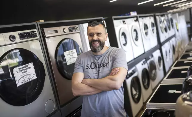 Mirnes Fatic, one of the owners of "Only fools and horses ltd." home appliance store, smiles during an interview for the Associated Press in Hadzici, suburb of Sarajevo, Bosnia, Wednesday, June 4, 2025. (AP Photo/Armin Durgut)