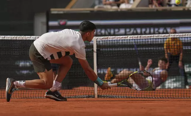 Spain's Carlos Alcaraz plays a volley to Ben Shelton of the U.S. during their fourth round match of the French Tennis Open, at the Roland-Garros stadium, in Paris, Sunday, June 1 2025. (AP Photo/Christophe Ena)