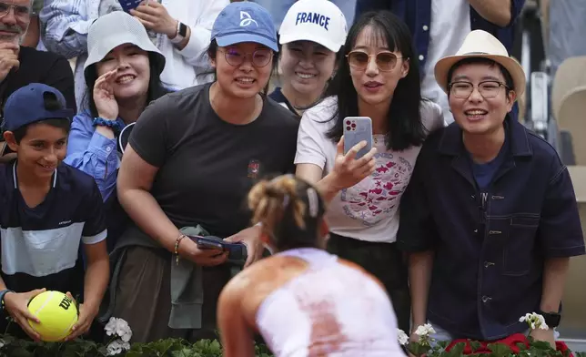 China's Zheng Qinwen celebrates with fans after beating Russia's Liudmila Samsonova during their fourth round match of the French Tennis Open, at the Roland-Garros stadium, in Paris, Sunday, June 1 2025. (AP Photo/Lindsey Wasson)