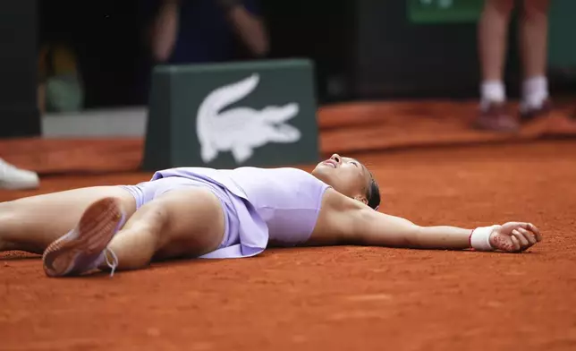 China's Zheng Qinwen lies on the court as she celebrates beating Russia's Liudmila Samsonova during their fourth round match of the French Tennis Open, at the Roland-Garros stadium, in Paris, Sunday, June 1 2025. (AP Photo/Lindsey Wasson)