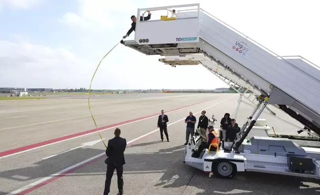 U.S. security personnel use a measuring tape to establish the required height for the boarding stairs that will be used for Air Force One ahead of President Donald Trump's arrival at Amsterdam Schiphol Airport for the NATO summit, taking place in The Hague, Netherlands, Tuesday, June 24, 2025. (AP Photo/Peter Dejong)