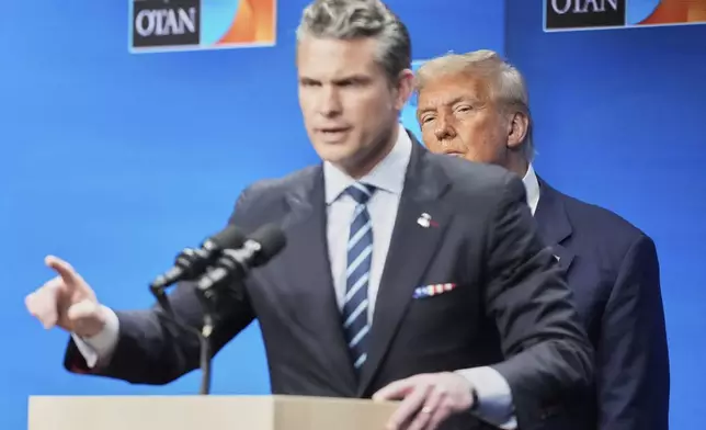 President Donald Trump watches Defense Secretary Pete Hegseth during a press conference after the plenary session at the NATO summit in The Hague, Netherlands, Wednesday, June 25, 2025. (AP Photo/Markus Schreiber)