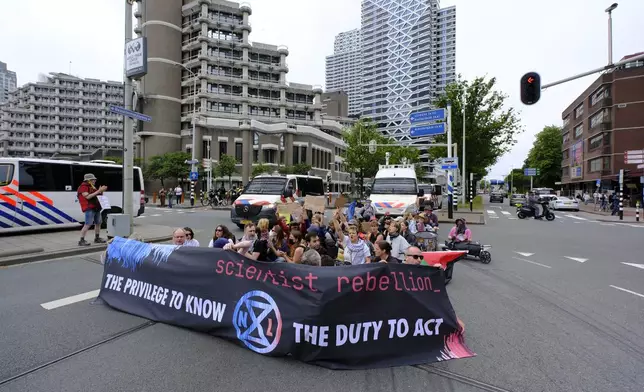 Demonstrators protest against the NATO summit as police follow them in The Hague, Netherlands, Wednesday, June 25, 2025. (AP Photo/Patrick Post)