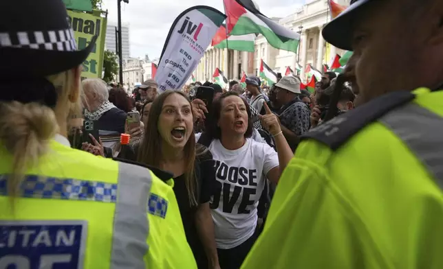 Demonstrators shout and gesture toward a police line during a protest by Palestine Action group in London, Monday, June 23, 2025. (AP Photo/Frank Augstein)