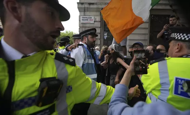 Police and demonstrators confront each other during a protest by Palestine Action group in London, Monday, June 23, 2025. (AP Photo/Frank Augstein)