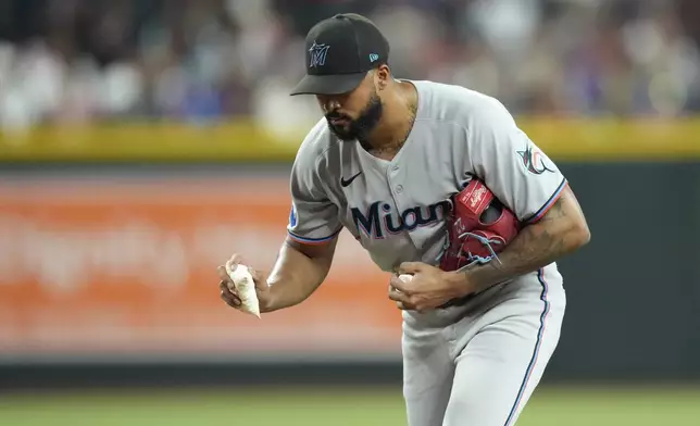 Miami Marlins starting pitcher Sandy Alcantara tosses away the rosin bag during the fourth inning of a baseball game against the Arizona Diamondbacks Saturday, June 28, 2025, in Phoenix. (AP Photo/Ross D. Franklin)