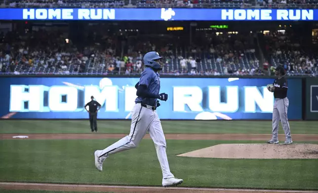 Washington Nationals' James Wood, center, rounds he bases on his two-run home run during the third inning of a baseball game against the Miami Marlins, Friday, June 13, 2025, in Washington. (AP Photo/Nick Wass)