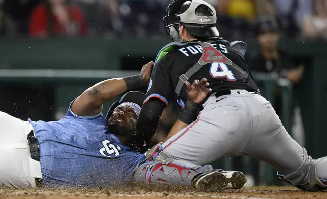 Washington Nationals' Josh Bell, left, is safe at home scoring on a single by Keibert Ruiz during the seventh inning of a baseball game against Miami Marlins catcher Nick Fortes, right, Friday, June 13, 2025, in Washington. (AP Photo/Nick Wass)