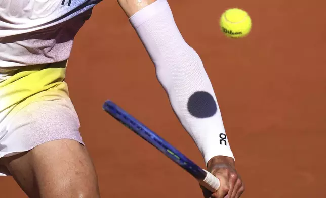 A ball casts its shadow on the arm of Ben Shelton of the U.S. as he plays Italy's Matteo Gigante , during their third round match of the French Tennis Open, at the Roland-Garros stadium, in Paris, Friday, May 30, 2025. (AP Photo/Thibault Camus)