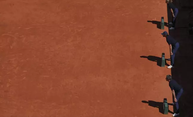 Line judges check the play during the third round match of the French Tennis Open between Denmark's Holger Rune and France's Quentin Halys, at the Roland-Garros stadium, in Paris, Friday, May 30, 2025. (AP Photo/Thibault Camus)
