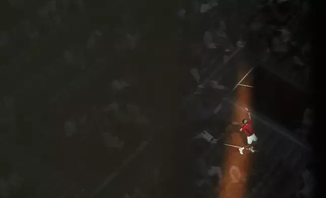 Fans are reflected in glass in an upper concourse as Serbia's Novak Djokovic serves against Austria's Filip Misolic during a third-round match of the French Tennis Open at the Roland-Garros stadium in Paris, Saturday, May 31, 2025. (AP Photo/Lindsey Wasson)