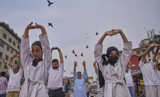 Students, along with activists of India's ruling Bharatiya Janata Party (BJP), perform yoga on International Day of Yoga at the city centre in Srinagar, Indian controlled Kashmir, Saturday, June 21, 2025. (AP Photo/Dar Yasin)