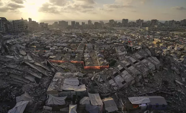 A tent camp for displaced Palestinians stretches among the ruins of buildings destroyed by Israeli bombardments in west of Gaza City, Saturday, June 21, 2025. (AP Photo/Jehad Alshrafi)