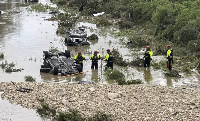 Authorities respond after vehicles were swept away by floodwaters in San Antonio, Tx., on Thursday, June 12, 2025. (AP Photo/Lekan Oyekanmi)