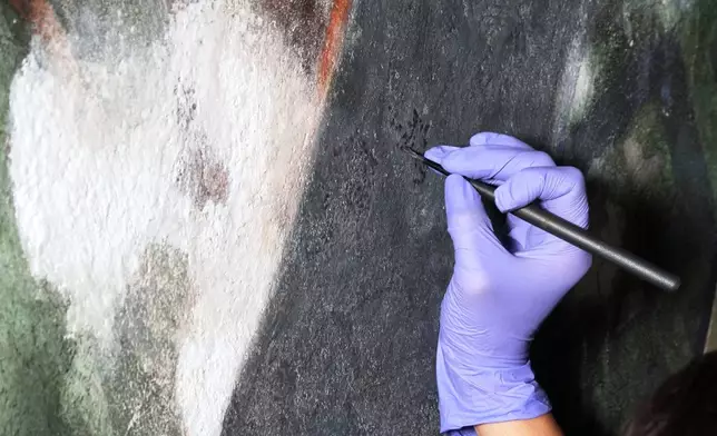 Standing on a 32-foot-tall scaffold, conservation technician Celeste Parrendo works on repairing a mural by Maxo Vanka inside St. Nicholas Croatian Catholic Church in Millvale, Pa., Monday, May 19, 2025. (AP Photo/Gene J. Puskar)