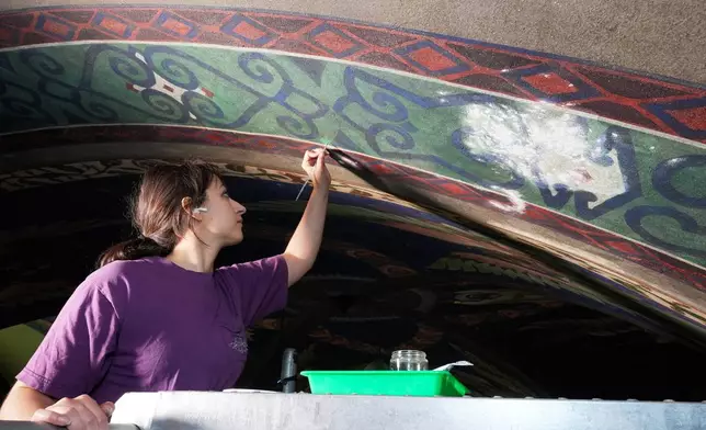 Art conservation technician Angelica Marks works on touching up a mural by Maxo Vanka on the ceiling of St. Nicholas Croatian Catholic Church in Millvale, Pa., Monday, May 19, 2025. (AP Photo/Gene J. Puskar)