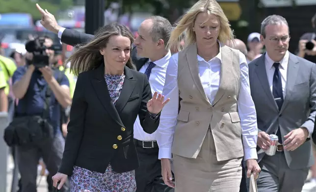 Karen Read, left, and her lawyer David Yanetti, second from left, acknowledge supporters as they return to the Dedham, Mass. courthouse, where the judge was to issue instructions to the jury in Read's trial at Norfolk Superior Court, Friday, June 13, 2025, in Dedham, Mass. (AP Photo/Josh Reynolds)