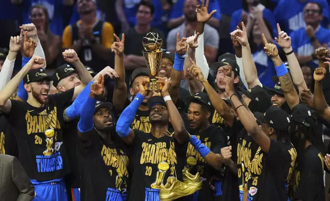 Oklahoma City Thunder guard Shai Gilgeous-Alexander, center, holds up the MVP trophy as he celebrates with his team after they won the NBA basketball championship with a Game 7 victory against the Indiana Pacers Sunday, June 22, 2025, in Oklahoma City. (AP Photo/Nate Billings)