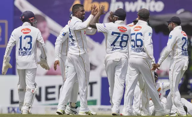 Sri Lanka's Tharindu Ratnayake, second left, celebrates the wicket of Bangladesh's Mominul Haque, right, during the first day of the first cricket test match between Sri Lanka and Bangladesh in Galle, Sri Lanka, Tuesday, June 17, 2025. (AP Photo/Eranga Jayawardena)