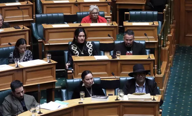 New Zealand lawmakers, Hana-Rāwhiti Maipi-Clarke, center at second row, Debbie Ngarewa-Packer, center in front row, and Rawiri Waititi, bottom right, who received lengthy suspensions from Parliament for a protest haka they performed last November, watch as other legislators debate their proposed bans in Wellington, New Zealand Thursday, June 5, 2025. (AP Photo/Charlotte Graham-McLay)