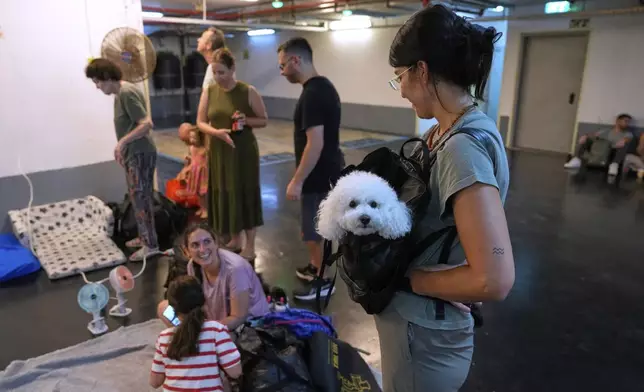 Israelis get ready to take shelter in a parking garage in prevention of a missile attack from Iran, in Tel Aviv, Israel, Monday, June 16, 2025. (AP Photo/Baz Ratner)