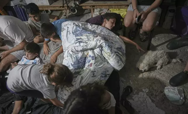 Israeli children take shelter during air raid sirens warning of incoming strikes by Iran, in Bnei Brak, near Tel Aviv, Israel, Tuesday, June 17, 2025. (AP Photo/Oded Balilty)