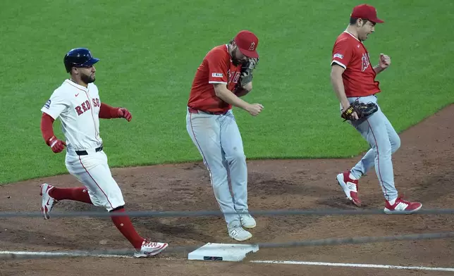 Los Angeles Angels first baseman Nolan Schanuel, center, jumps out of the way after making the out on a grounder by Boston Red Sox's Abraham Toro, as pitcher Yusei Kikuchi celebrates, in the third inning of a baseball game, Tuesday, June 3, 2025, in Boston. (AP Photo/Robert F. Bukaty)