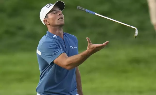 eViktor Hovland, of Norway, tosses his club after making his approach to the 18th green during the third round of the U.S. Open golf tournament at Oakmont Country Club Saturday, June 14, 2025, in Oakmont, Pa. (AP Photo/Seth Wenig)