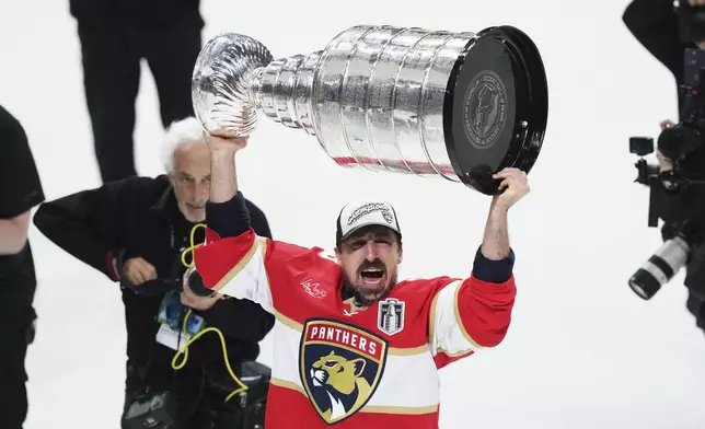 Florida Panthers' Brad Marchand (63) raises the Stanely Cup after defeating the Edmonton Oilers in Game 6 of the NHL hockey Stanley Cup Final in Sunrise, Fla., Tuesday, June 17, 2025. (Nathan Denette/The Canadian Press via AP)