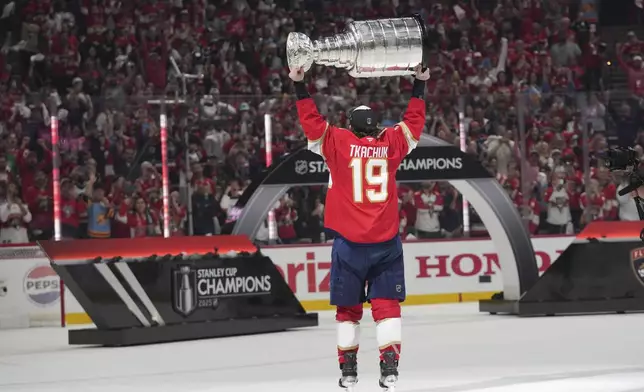 Fans cheer as Florida Panthers left wing Matthew Tkachuk (19) lifts the Stanley Cup after defeating the Edmonton Oilers in Game 6 of the NHL hockey Stanley Cup Final Tuesday, June 17, 2025, in Sunrise, Fla. (AP Photo/Lynne Sladky)