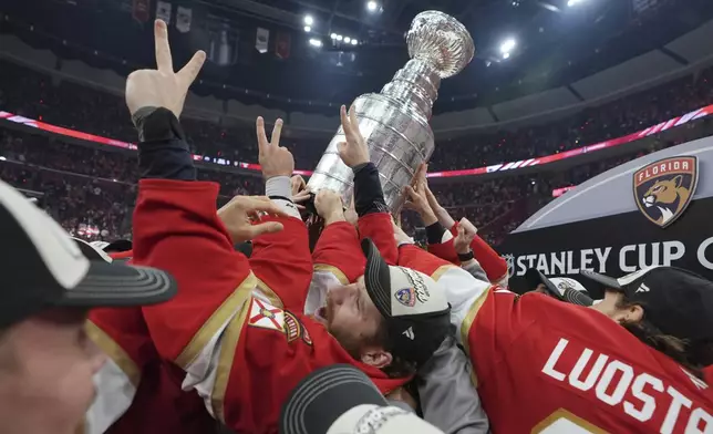 Florida Panthers left wing Matthew Tkachuk helps raise the Stanley Cup trophy after defeating the Edmonton Oilers in Game 6 of the NHL hockey Stanley Cup Final Tuesday, June 17, 2025, in Sunrise, Fla. (AP Photo/Lynne Sladky)