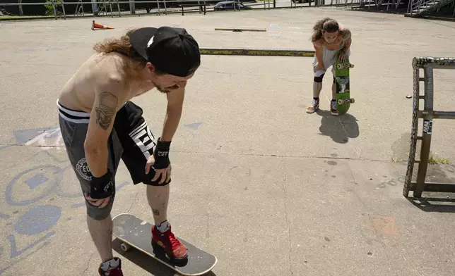 Skateboarders Anthony Eadens and Tommy Wright catch their breath after skating at the Dave Armstrong Extreme Park on Sunday, June 22, 2025, in Louisville, Ky. (AP Photo/Jon Cherry)