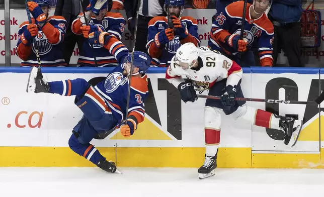 Florida Panthers' Tomas Nosek (92) checks Edmonton Oilers' Viktor Arvidsson (33) during the second period in Game 2 of the NHL hockey Stanley Cup Finals in Edmonton, Alberta, Friday, June 6, 2025. (Jason Franson/The Canadian Press via AP)