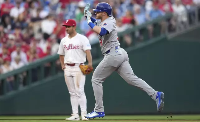 Chicago Cubs' Ian Happ ,right, reacts past Philadelphia Phillies third baseman Otto Kemp after hitting a home run against pitcher Mick Abel during the third inning of a baseball game Tuesday, June 10, 2025, in Philadelphia. (AP Photo/Matt Slocum)