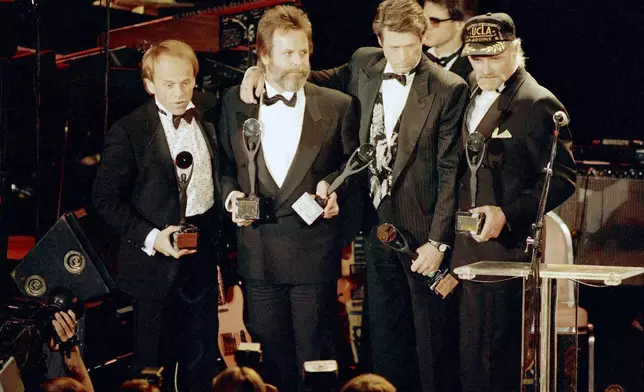FILE - The Beach Boys, from left, Al Jardine, Carl Wilson, Brian Wilson and Mike Love, hold their trophies after being inducted into the Rock 'n' Roll Hall of Fame in New York, Jan. 21, 1988. (AP Photo/Ron Frehm, File)