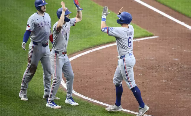 Texas Rangers' Josh Jung (6) celebrates his two-home run with Evan Carter, center, and Jonah Heim, left, during the fourth inning of a baseball game against the Baltimore Orioles, Wednesday, June 25, 2025, in Baltimore. (AP Photo/Nick Wass)