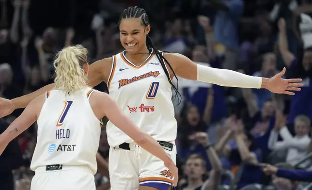 Phoenix Mercury forward Satou Sabally (0) celebrates a made 3-pointer by Mercury guard Lexi Held (1) during the second half of a WNBA basketball game against the Golden State Valkyries Thursday, June 5, 2025, in Phoenix. (AP Photo/Ross D. Franklin)